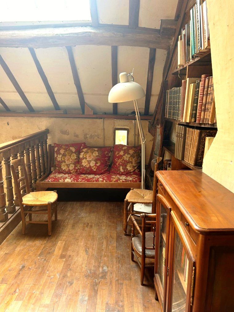 Une banquette et de vieux livres sur le palier du grenier