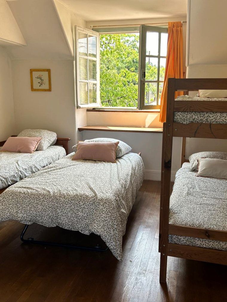 La chambre des enfants, trois lits faits et des lits superposés