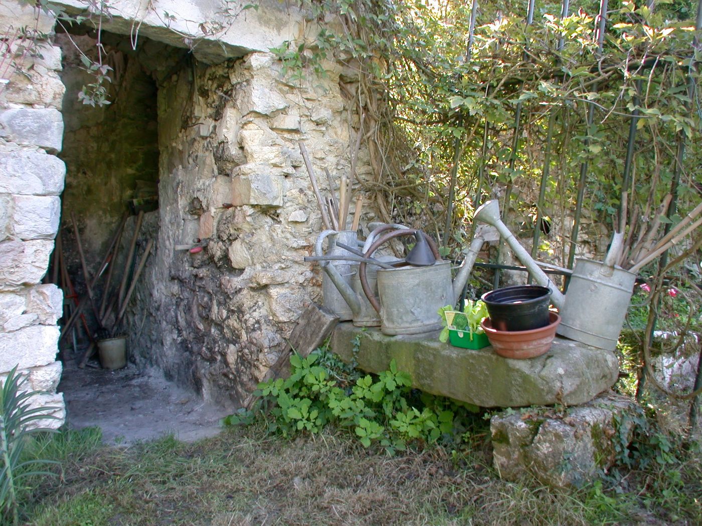 Les arrosoirs sous la voûte de pierre