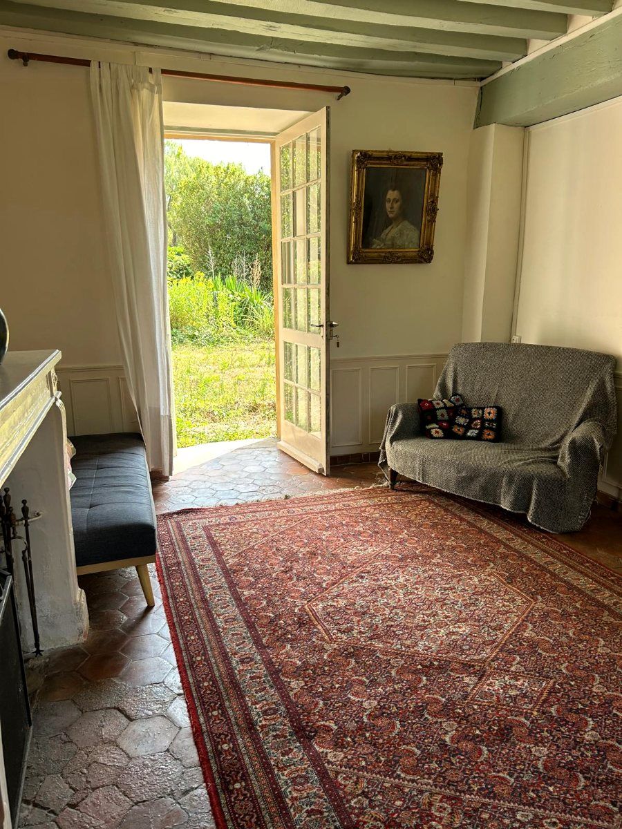 Un salon, la porte-fenêtre ouverte sur le jardin