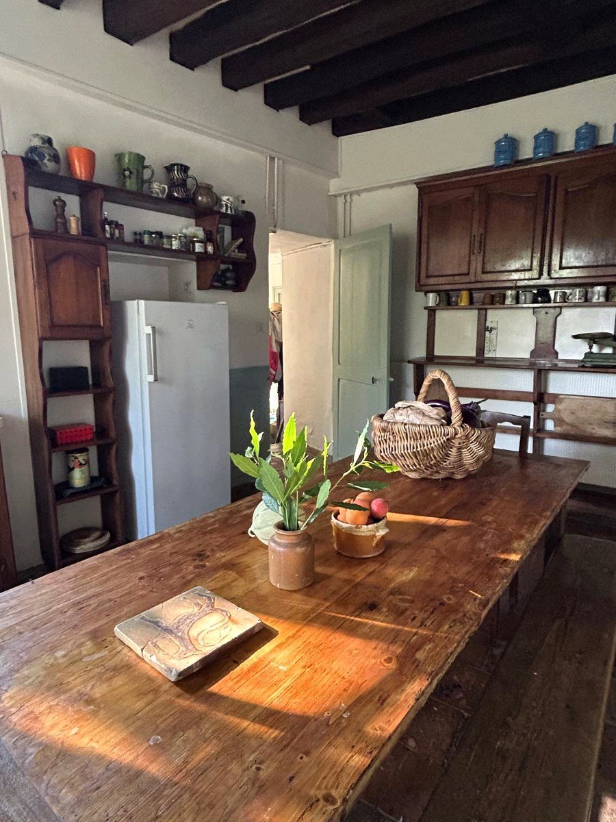 La table de la cuisine du Fort de Challeau, un panier de légumes dans la lumière de l’après-midi