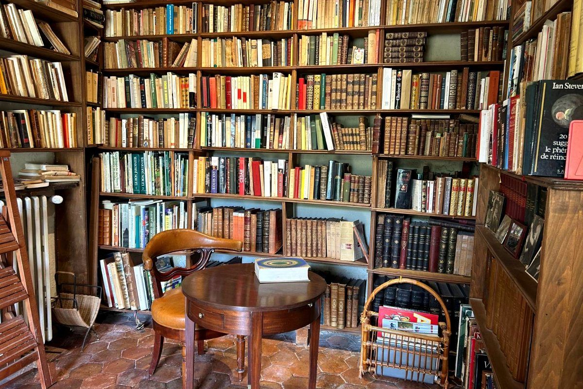 La bibliothèque du Fort de Challeau, des livres du sol au plafond et un guéridon