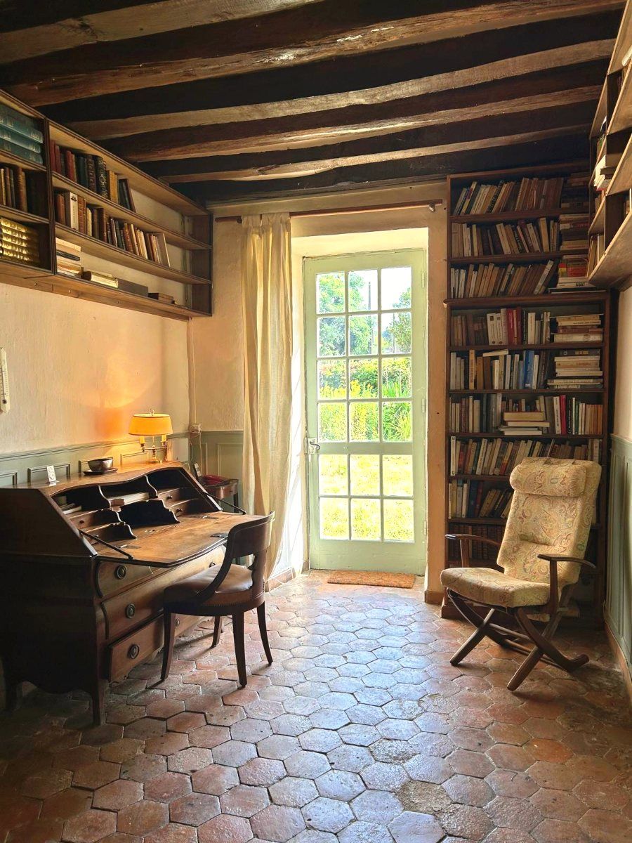 Le bureau, son secrétaire, ses rayonnages et une porte sur l’herbe