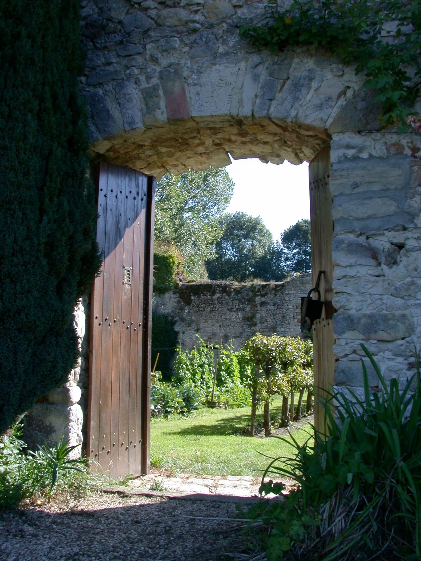 Une porte dans la muraille, ouverte sur le potager